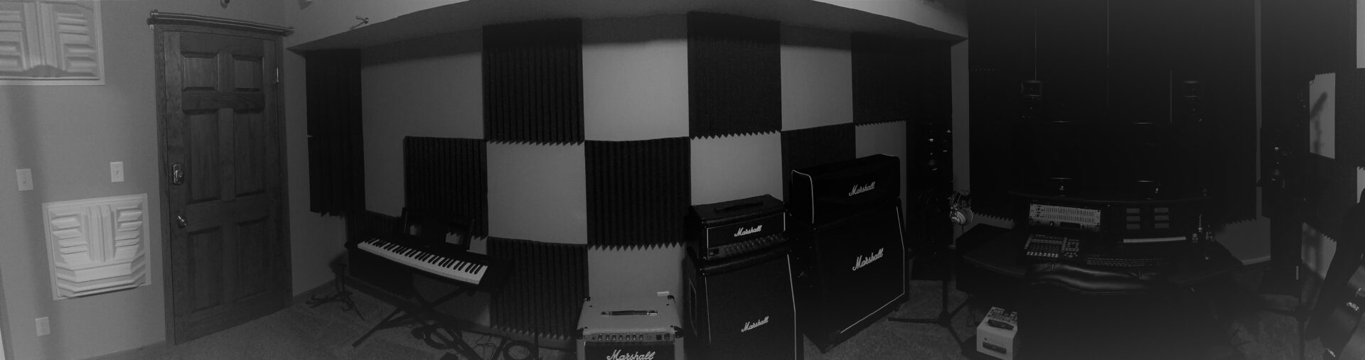 music production room with a keyboard and amps