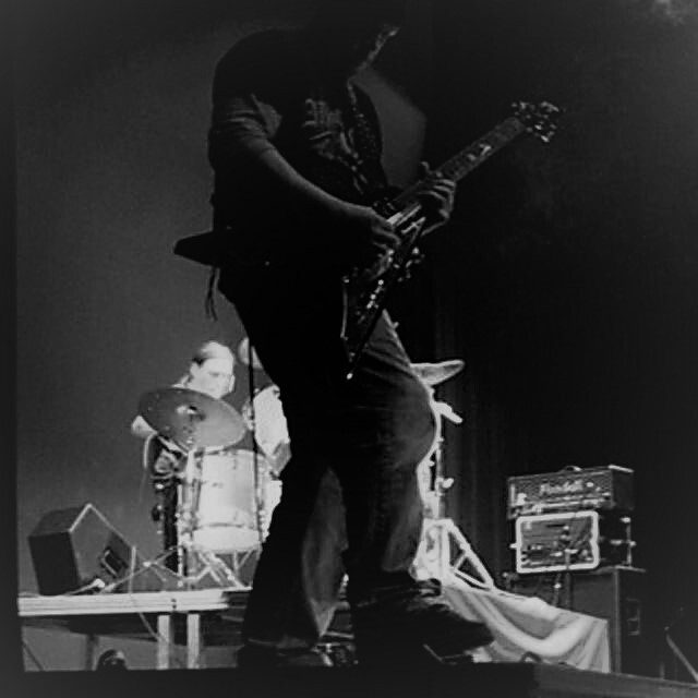 black and white image of a man playing a guitar